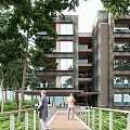Multi story Boutique Guesthouse with Large Windows Balconies Lush Green Trees and Wooden Walkway