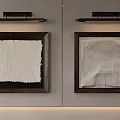 Textured Abstract Paintings in Dark Wooden Frames on Light Gray Wall with Black Light Fixtures