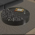 Modern Round Black Coffee Table with Textured Surface Holding Notebook Pen Glass and Small Plant