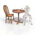 Round Wooden Table With Two Chairs One Wooden And One Ornate Metal With Plates