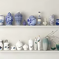 Traditional And Modern Ceramic Vessels Displayed On White Shelves With Blue White And Green Designs
