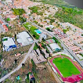 Modern Town Aerial View With Green Spaces Buildings And Sports Field