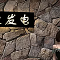 Woman Standing By Stone Wall With Love Power Sign And Cherry Blossom Trees