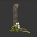 Modern Stone Pillar Display With Stacked Dark Stones And Surrounding Green Plants