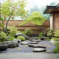 Japanese Courtyard Garden With Bamboo Fence Stepping Stones Pebbles And Lush Greenery