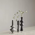 Minimalist Decorative Geometric Vases In Gray Black With Leafy Sprigs On White Countertop