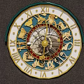 Decorative Zodiac Clock With Roman Numerals Gold Zodiac Signs Green Frame White Dial And Ornate Design