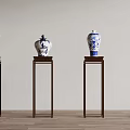 Blue and White Ceramic Vases with Traditional Patterns on Dark Wooden Stands Against Light Wall