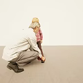 Elderly Man And Young Boy Tying Shoelaces Together In Indoor Setting With Light Wall And Gray Floor