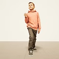 Man Wearing Orange Hoodie Dark Pants Sneakers Walking On Minimal Background