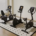 Modern Fitness Room Featuring Three Exercise Bikes With Digital Displays On Grid Mat