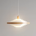 Gold And White Multi Layered Circular Chandelier Hanging Against Gray Background Illuminated