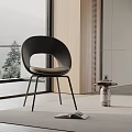 Modern Upholstered Dining Chair With Black Curved Back And Metal Legs Near Bright Window