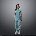 A woman in light blue top and pants standing against gray background wearing white shoes