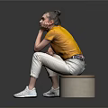 Woman In Yellow Top Sitting On Round Stool With White Pants And Reflective Floor