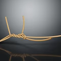 Beige Twisted Rope Knot Displayed On Dark Smooth Surface With Subtle Reflection
