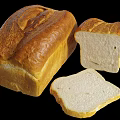 Golden Brown Bread Loaf And Sliced Pieces With White Interior On Black Background