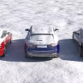 Three Snow Covered Black Blue And Red Cars Parked On Snowy Ground
