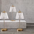 Three Elegant Crystal Lamps With Gold Base And Transparent Shade On Gray Display Stand