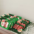 Fresh Packaged Meat Products in Green Trays with Various Slices Displayed on Foil Tray