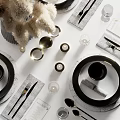 Modern Tableware Set With Black Plates Bowls Transparent Glassware Silver Cutlery And White Floral Arrangement