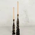 Decorative Gold And Black Candle Holders With White Candles On White Wall Background