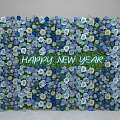 Floral Installation For New Year With Blue Purple White Flowers And Happy New Year Text