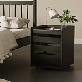 Sleek Black Nightstand With Drawers Featuring White Lamp Green Plants In Vase And Cup