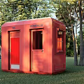 Red GÖVENEK Mobile Toilet in Wooded Outdoor Area with Green Grass