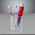 Essential Daily Household Essentials With Two Toothbrushes And Toothpaste Tube In Transparent Glass Cup