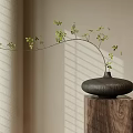 Black Vase With Green Leaf Branches On Wooden Pedestal Against Light Wall With Sunlight Shadows