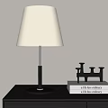 Modern Table Lamp with Fabric Shade and Metal Base Near Black Candle Holder on Books