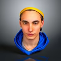 Portrait of a Man Wearing Yellow Headband and Blue Hoodie Against Gray Background