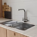 Stainless Steel Kitchen Sink with Modern Faucet on Countertop and Wooden Cutting Boards