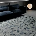 Modern Living Room Featuring Stylish Abstract Patterned Rug Navy Sofa And Round Lamp