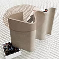Modern Light Colored Curved Side Table With Photo Card On Wavy Textured Floor