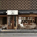 Starbucks Coffee Storefront With Wooden Lattice Wall White Awning Outdoor Seating And Green Plants