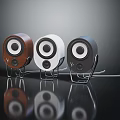 Three Compact Brown White Black Speakers with Circular Drivers on Stands Dark Background Reflection