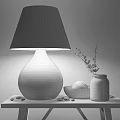 Table Lamp with Glass Base Fabric Shade Pebbles on Wooden Table and Green Plant