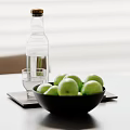 Green Apples In Black Bowl With Clear Glass Bottle And Cup On White Table Trays