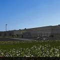 Modern Industrial Factory Building With Green Lawn Flower Beds And Delivery Truck Under Blue Sky