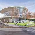 Modern Commercial Landscape With Curved Glass Building Trees Plaza Silver Sculpture People Strolling And Greenery