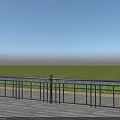 Black Iron Decorative Fence With Blue Flowers Along Green Grass On Wooden Deck