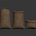 Three Burlap Sacks With Red Grains Food In Different Sizes On Dark Surface