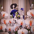 Fashion Mannequins In Stylish Outfits With Hats Surrounded By White Orchids In Decorative
