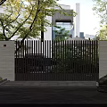Modern Building Facade with Wooden Slat Gate Stone Wall Wall Lights and Greenery
