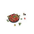 Fresh Ripe Strawberries in Black Bowl with Green Leaves and Scattered Berries on White Background