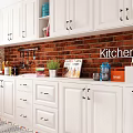 White Kitchen Cabinets With Red Brick Wall Cooking Tools Plants And Magazines On Countertop