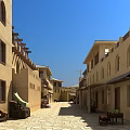 Traditional Earth Toned Guesthouse Architecture With Arched Windows Stone Alley And Outdoor Seating