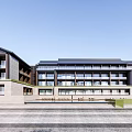Traditional Modern Hotel Building With Multiple Floors Large Glass Windows And Outdoor Courtyard